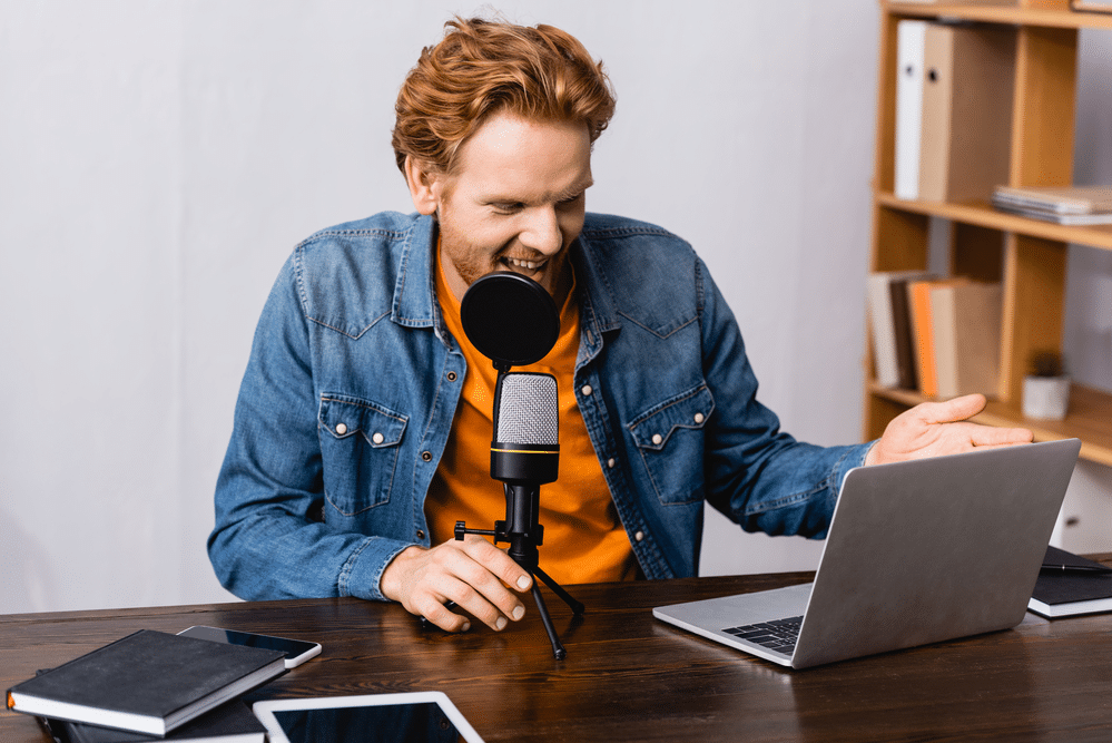 Happy male podcasting host creating a podcast that resonates with his audience